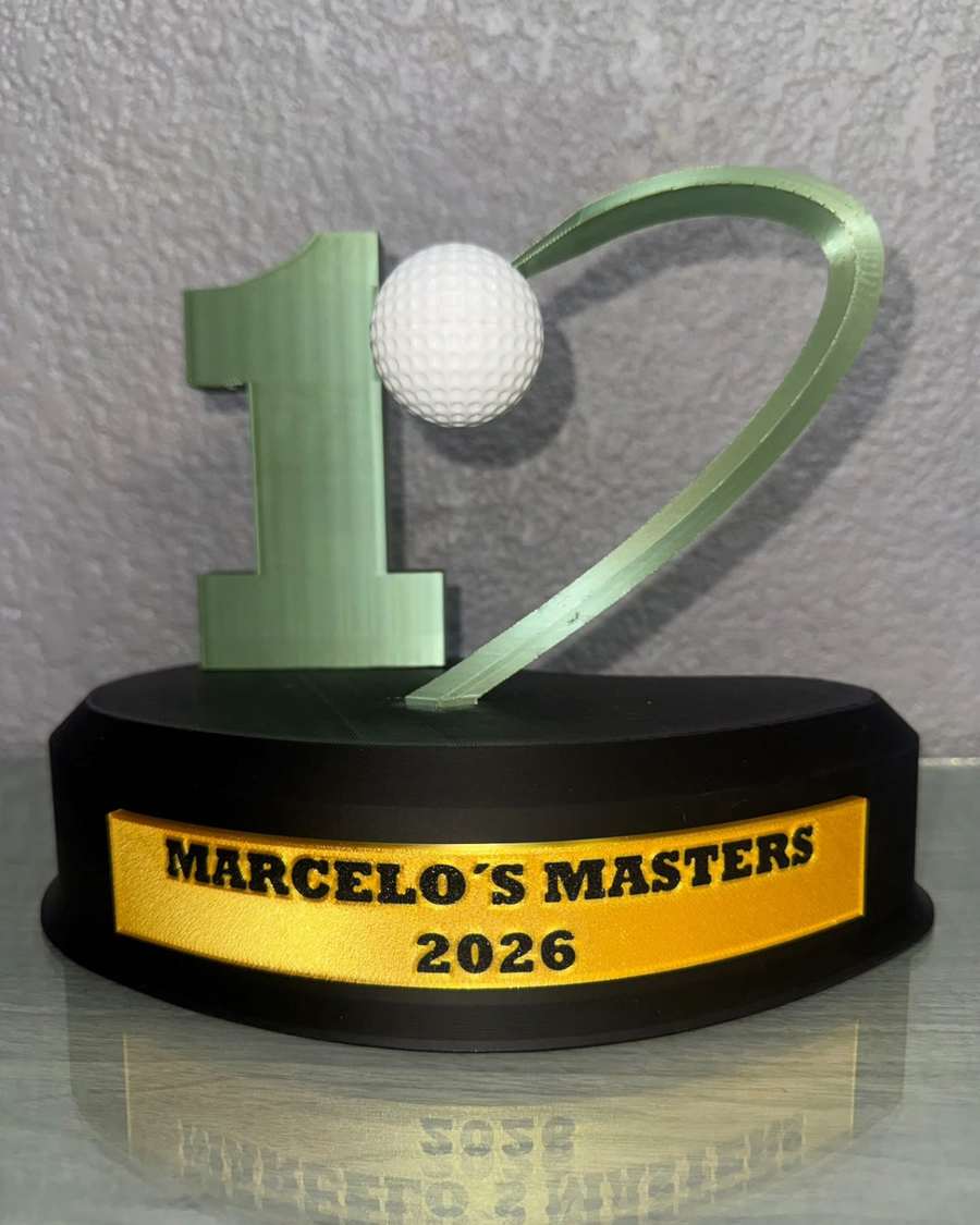 Trofeo de golf verde con pelota blanca sobre base negra y placa dorada